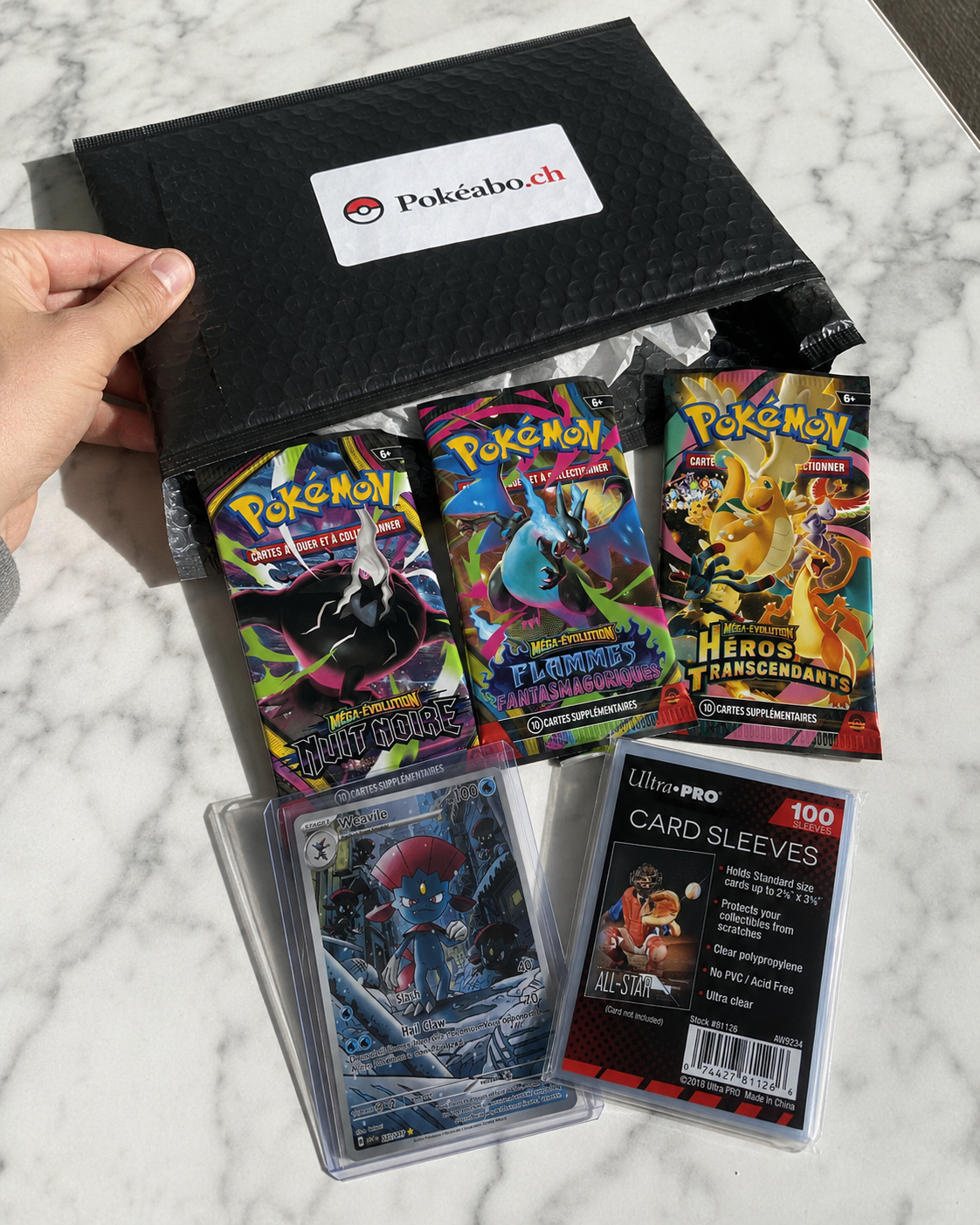 Box Pokéabo Découverte avec 3 boosters Méga Évolution, une carte Weavile et un pack de 100 sleeves Ultra Pro